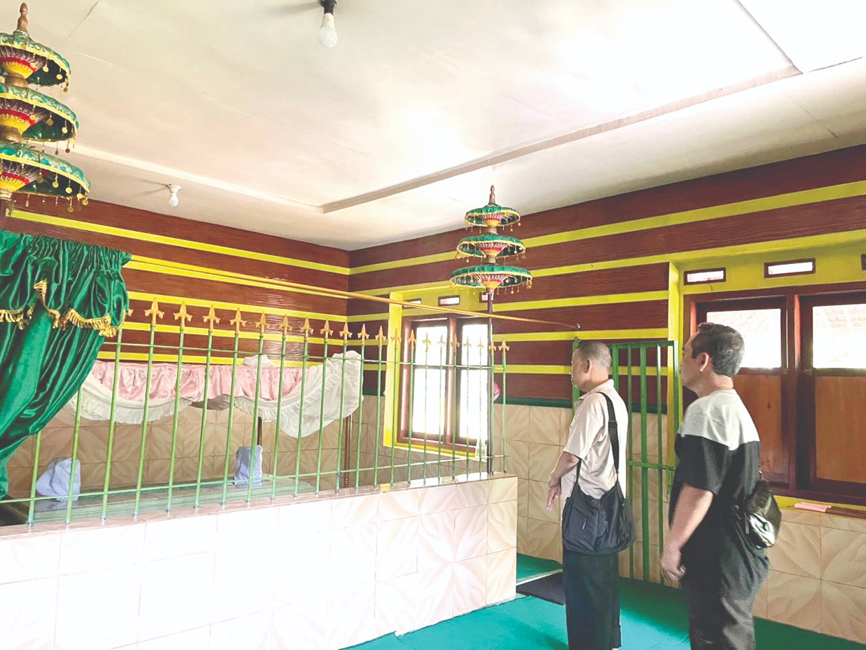 KHUSYUK: Dua peziarah tampak khidmat melantunkan doa di makam Mbah Patok yang dikenal sebagai tokoh babat alas Songgoriti kemarin (9/2).