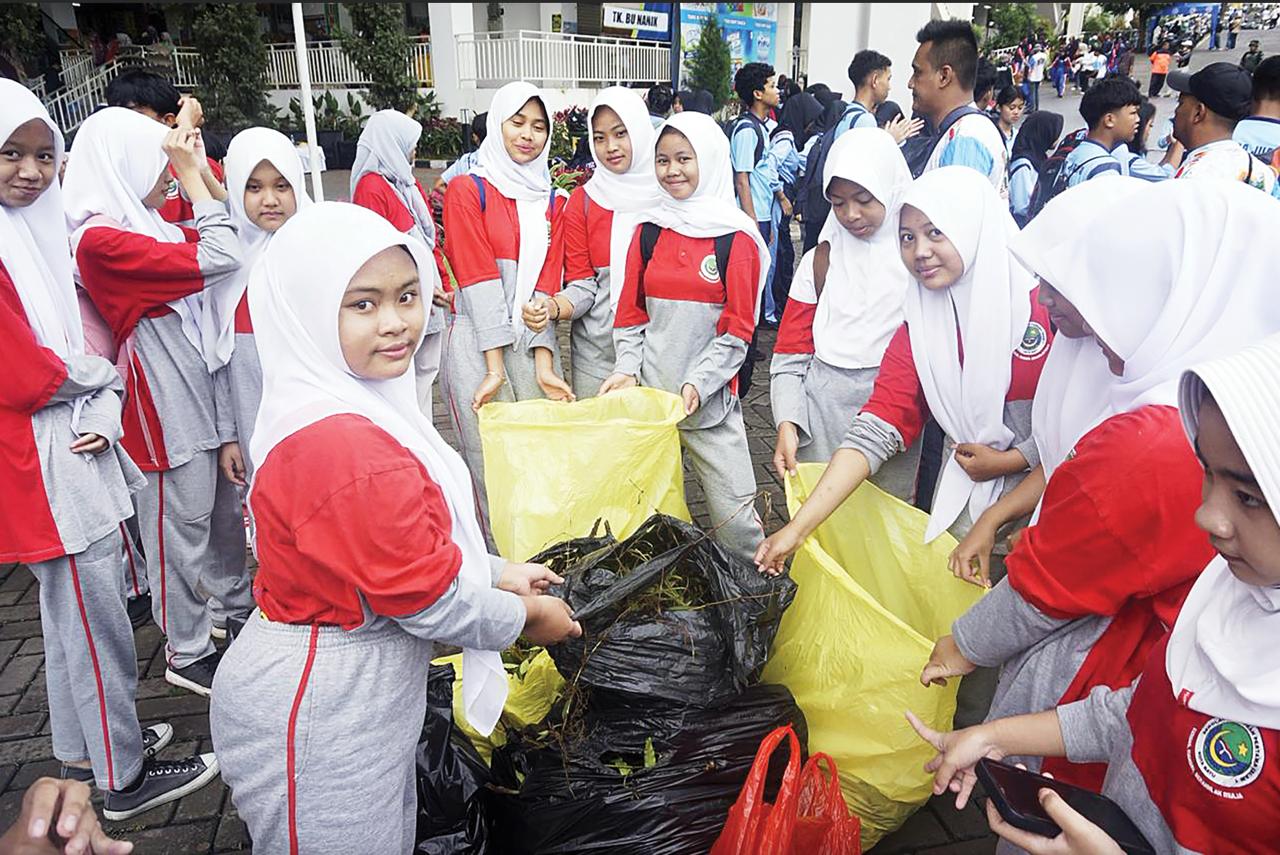 PEDULI SAMPAH: Beberapa siswa tampak mengantongi sampah dalam plastik besar di Pasar Induk Among Tani Batu kemarin pagi (13/2).