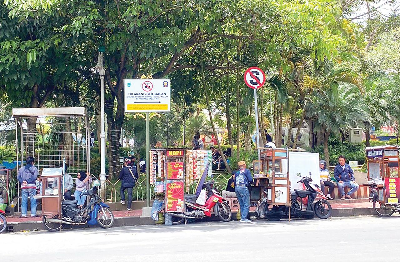 MAKIN BERANI: PKL liar menjamur di bibir Alun-Alun Kota Wisata Batu meski sudah dipasang rambu larangan berjualan kemarin (15/2). (RORI DINANDA BESTARI/RADAR BATU)
