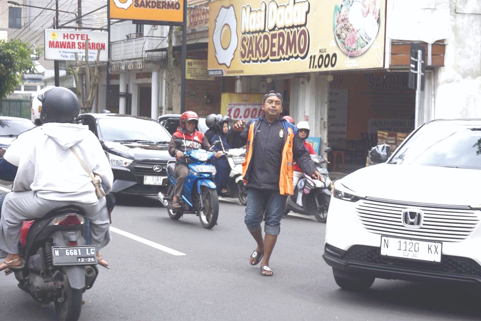 JADI SOROTAN: Salah seorang jukir sedang membantu pengguna jasa parkir keluar dari kawasan Jalan Diponegoro beberapa waktu lalu.