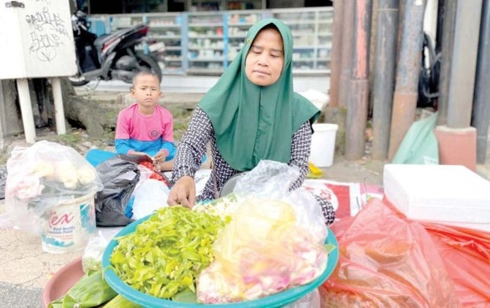 HARGA MELONJAK: Salah seorang pedagang kaki lima di Jalan Ahmad Yani, Kecamatan Blimbing, menjajakan bunga tabur beberapa waktu lalu