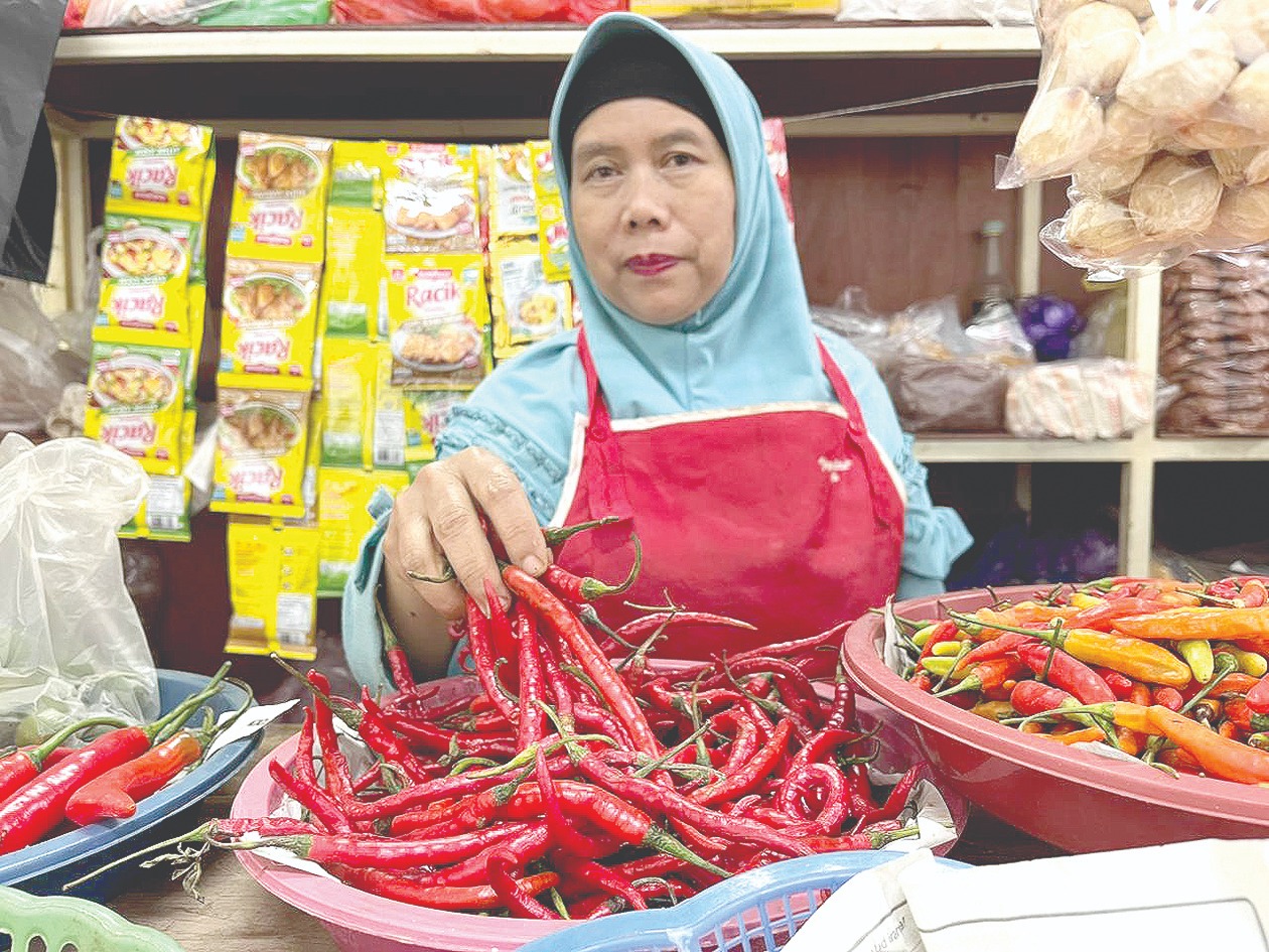MULAI MELANDAI: Salah seorang pedagang di Pasar Induk Among Tani menunjukkan stok cabai merah besar yang harganya mulai melandai kemarin (22/2). (Zanadia Manik Fatimah/Radar Batu)