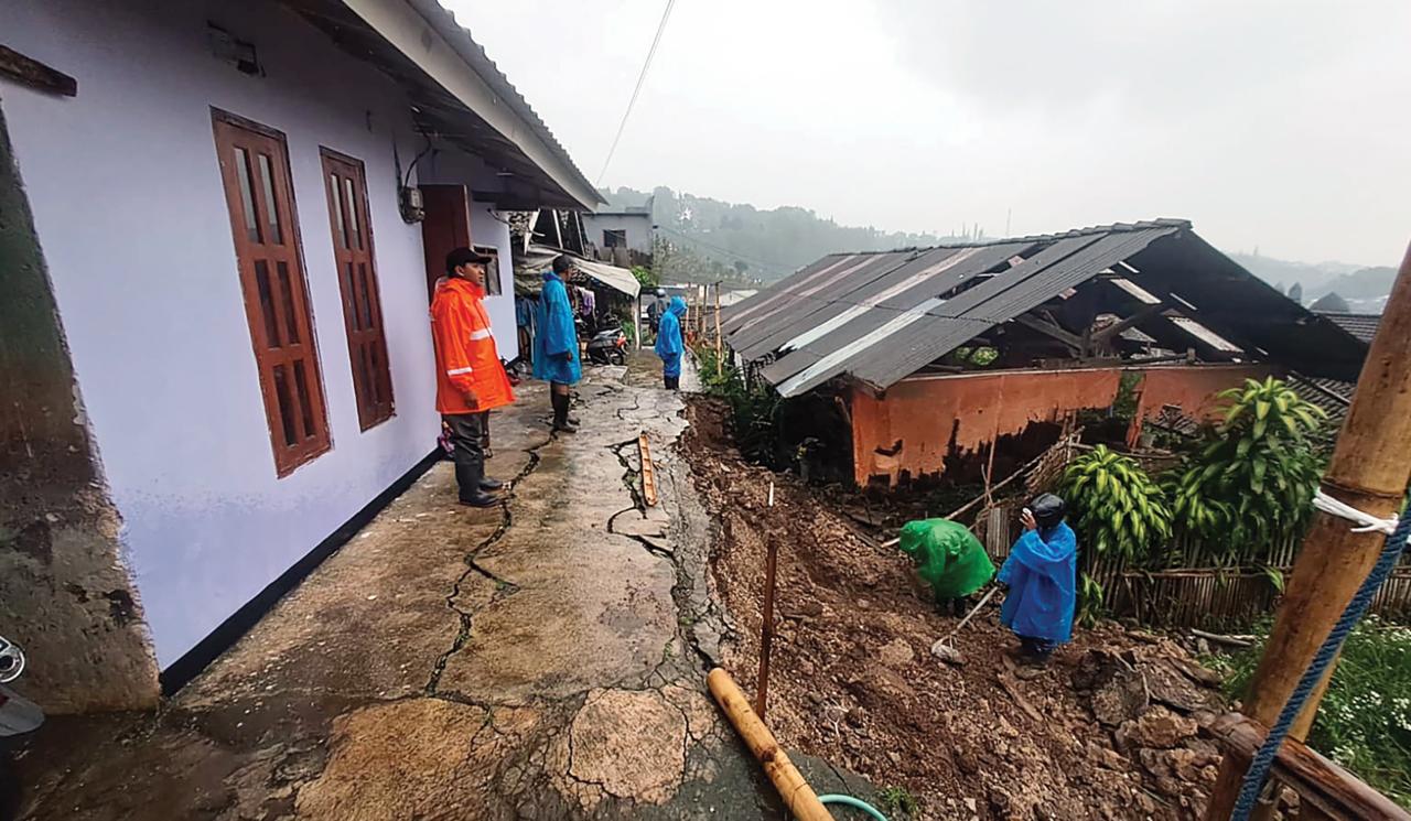 DITANGANI: Proses normalisasi pascabencana plengsengan ambrol di Desa Tulungrejo, Kecamatan Bumiaji akiba hujan deras Minggu (22/2) lalu.   