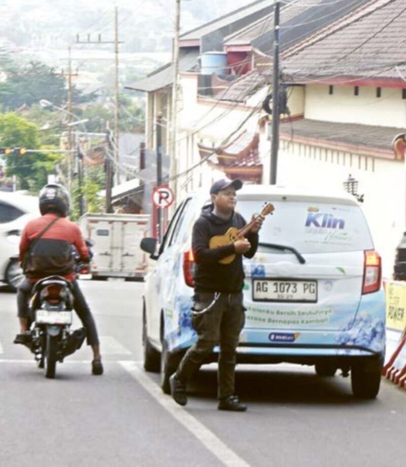 MASIH BERKELIARAN: Pengamen di lampu merah Jalan Ahmad Yani masih berkeliaran sejak kemarin (27/2). RORI DINANDA BESTARI/RADAR BATU 