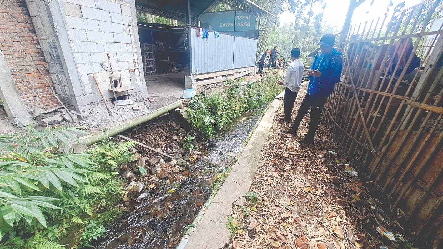 AMBROL: Petugas BPBD Kota Batu melakukan kajian usai ambrolnya irigasi di Jalan Kalilanang Kopi, Desa Bumiaji kemarin (2/3).