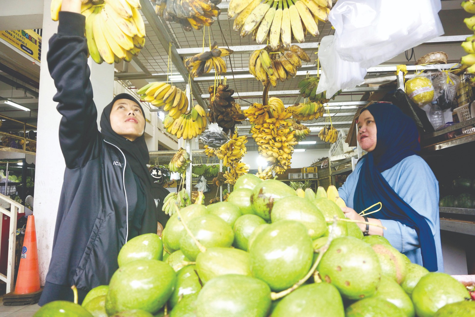PENJUALAN LESU: Salah seorang penjual buah melayani pembeli di Pasar Induk Among Tani Batu kemarin (9/3).