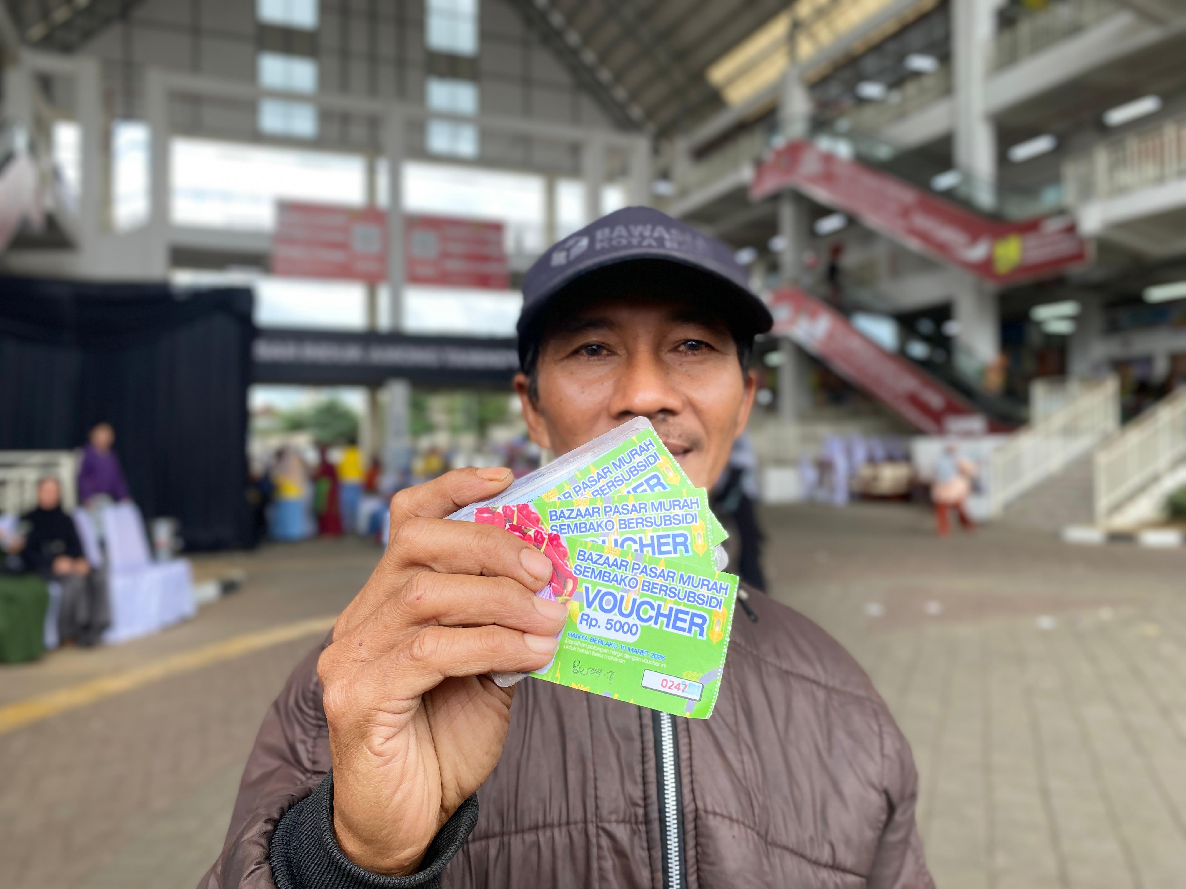 Warga menunjukkan voucher belanja di Pasar Among Tani, Selasa (10/3). (Rori Dinanda Bestari/Radar Malang)