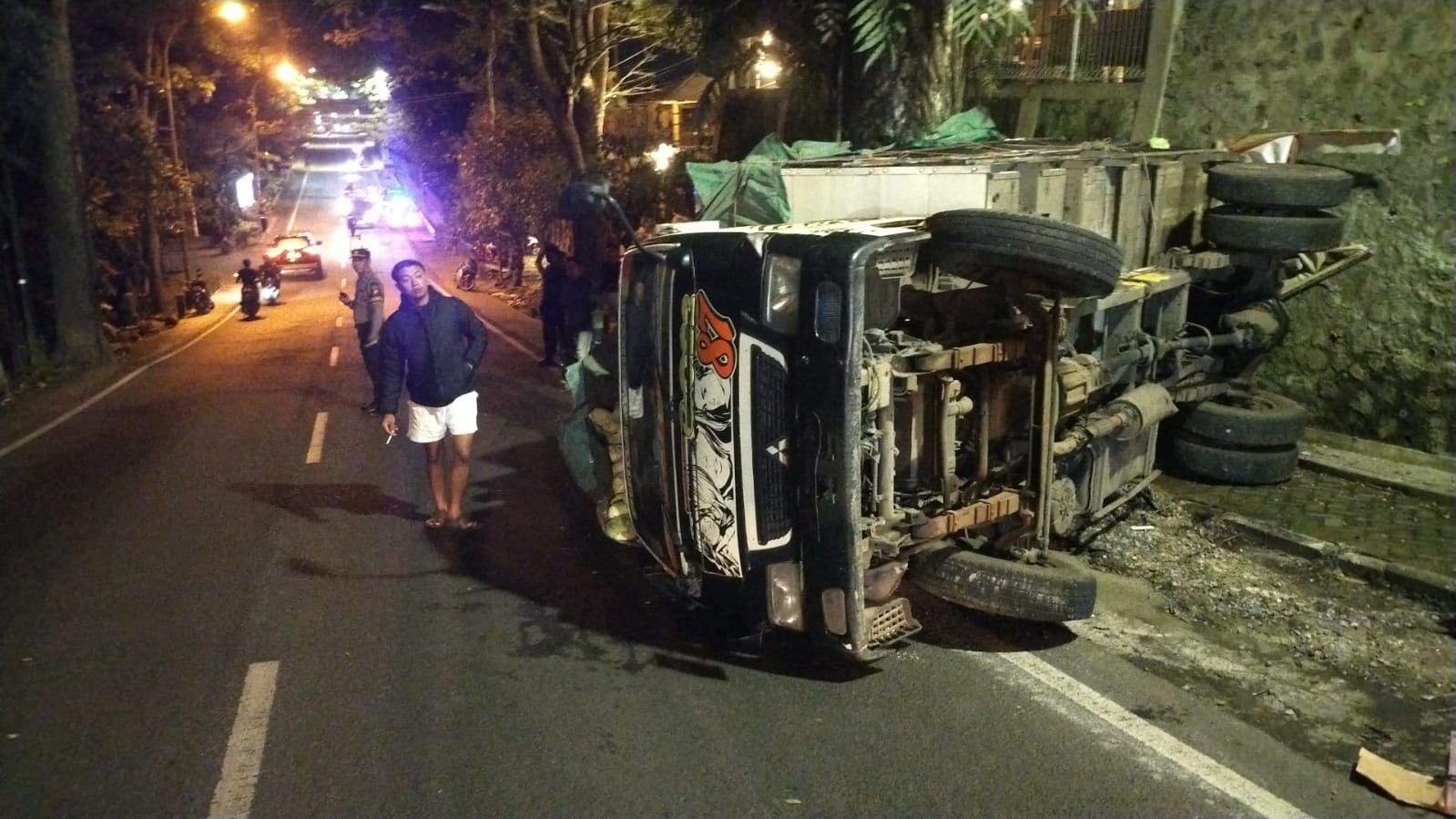 Kondisi truk muatan sayur yang terguling di tanjakan Pandanrejo, Bumiaji, Selasa (10/3) malam. (Polres Batu for Radar Batu)