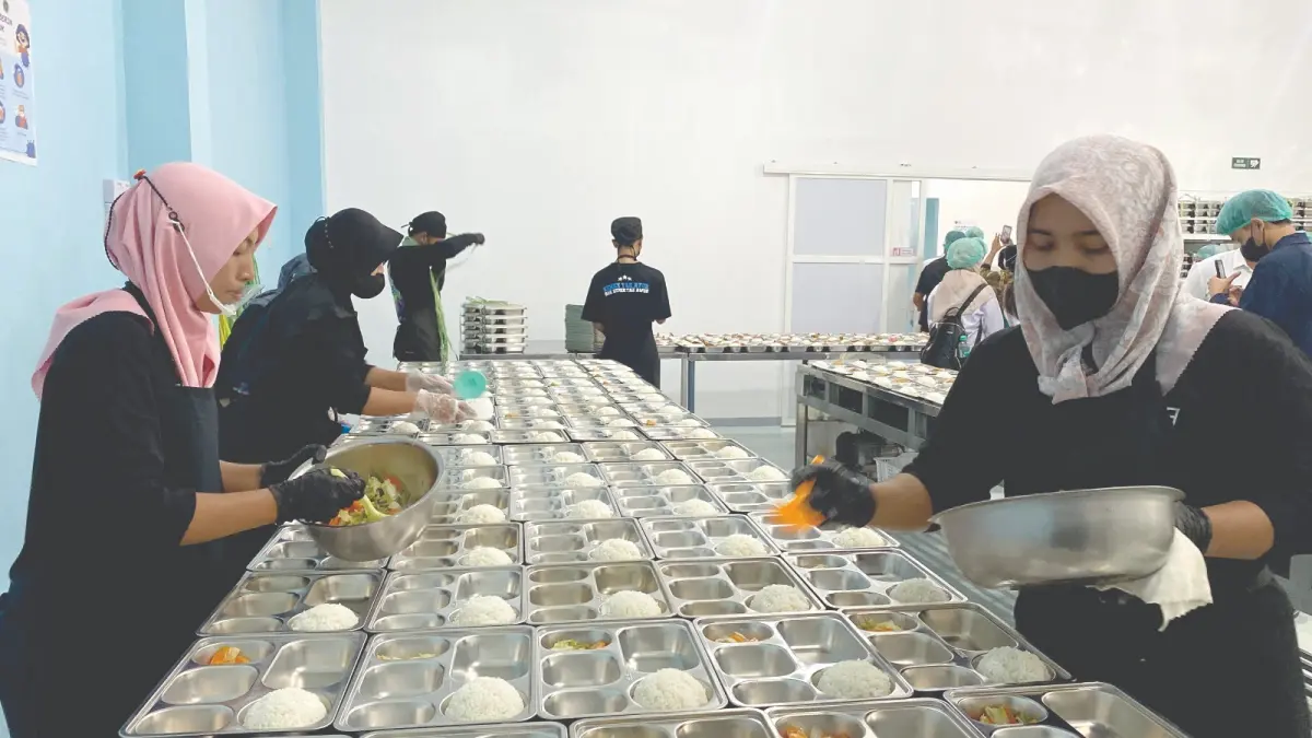 SIAPKAN MBG: Sejumlah petugas di dapur SPPG Sulaiman Al Haj tengah menata MBG beberapa waktu lalu.