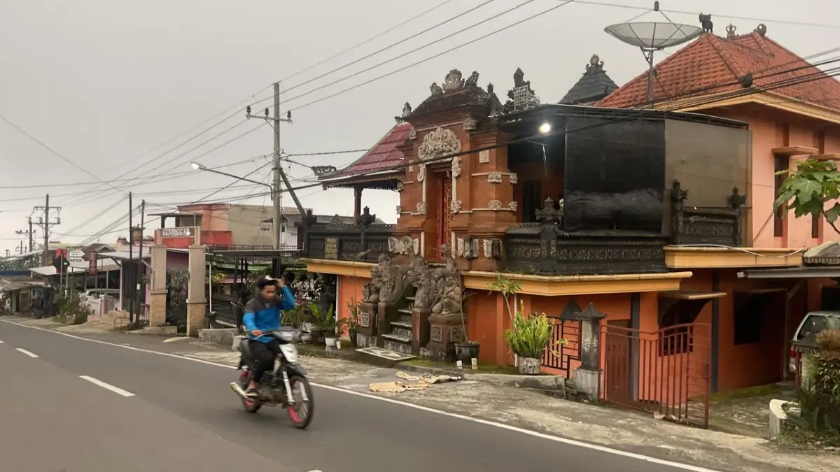 Warga melintasi depan pura di Desa Tulungrejo, Kecamatan Bumiaji, Kota Batu beberapa waktu lalu. (Rori Dinanda Bestari/Radar Malang)