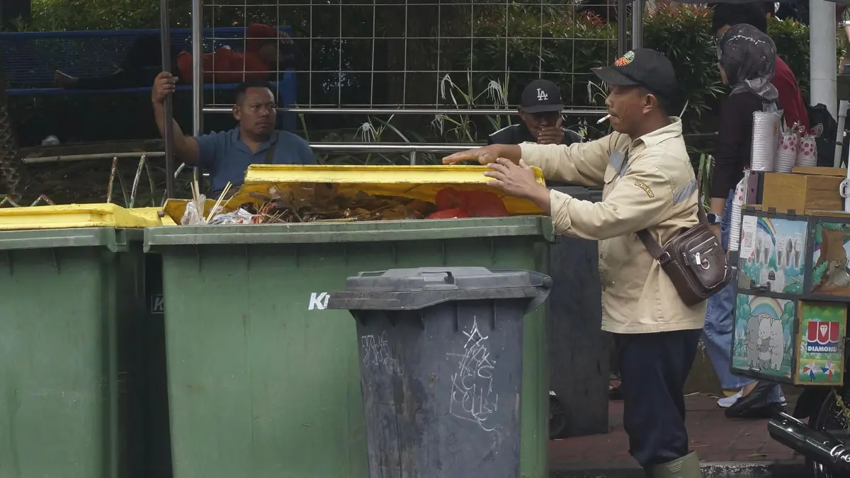 ONE DAY PROCESS: Salah seorang petugas kebersihan menyisir sampah di kawasan Alun-Alun Kota Wisata Batu saat libur Lebaran beberapa waktu lalu.