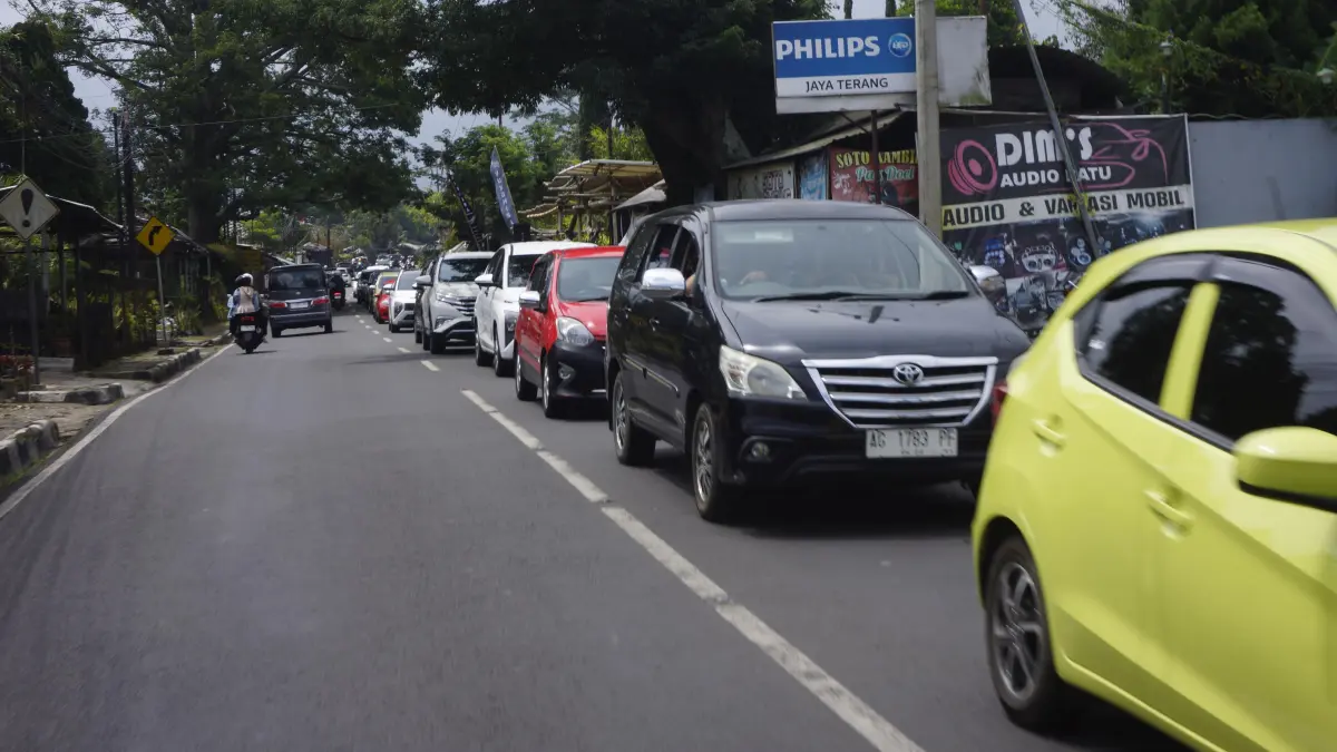 MENGULAR: Sejumlah kendaraan mengantre di Jalan Bukit Berbunga, Kecamatan Bumiaji untuk meninggalkan Kota Batu siang ini (29/3).