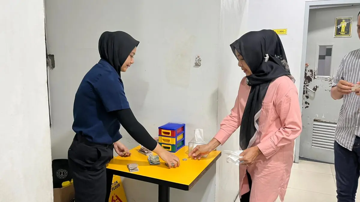 TUAI KRITIK: Salah seorang pengunjung membayar tarif toilet di pusat perbelanjaan di Kota Malang beberapa waktu lalu. NAHDIATUL AFFANDIAH/RADAR MALANG