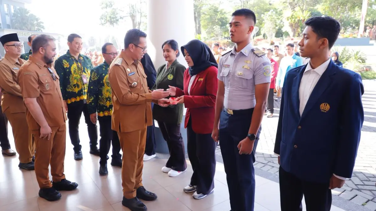 BERIKAN BEASISWA: Wali Kota Batu Nurochman menyerahkan beasiswa secara simbolis kepada salah satu mahasiswa di Balai Kota Among Tani Batu pagi ini (30/3).