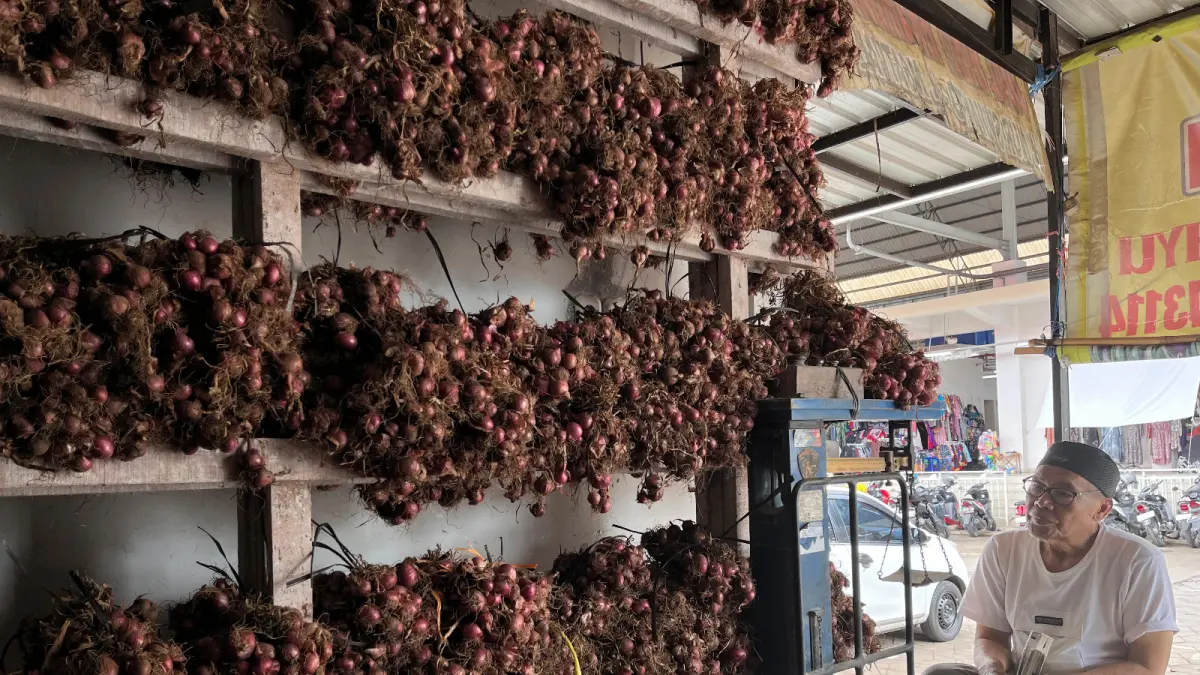 STOK BAWANG MERAH: Salah seorang penjual bawang merah menjaga kiosnya di Pasar Sayur Kota Batu beberapa waktu lalu. ZANADIA MANIK FATIMAH/RADAR BATU 