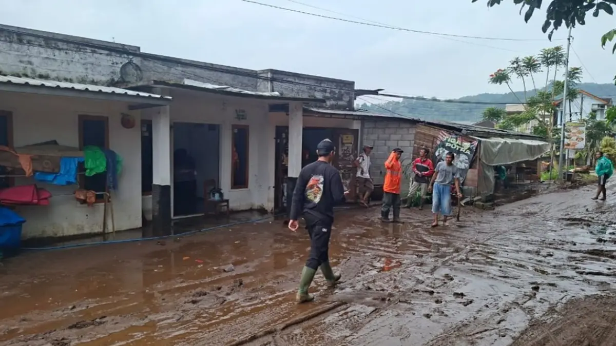 Warga Desa Tulungrejo, Kecamatan Bumiaji membersihkan lumpur bekas banjir pada Kamis (2/4) sore. (Pusdalops BPBD Kota Batu)