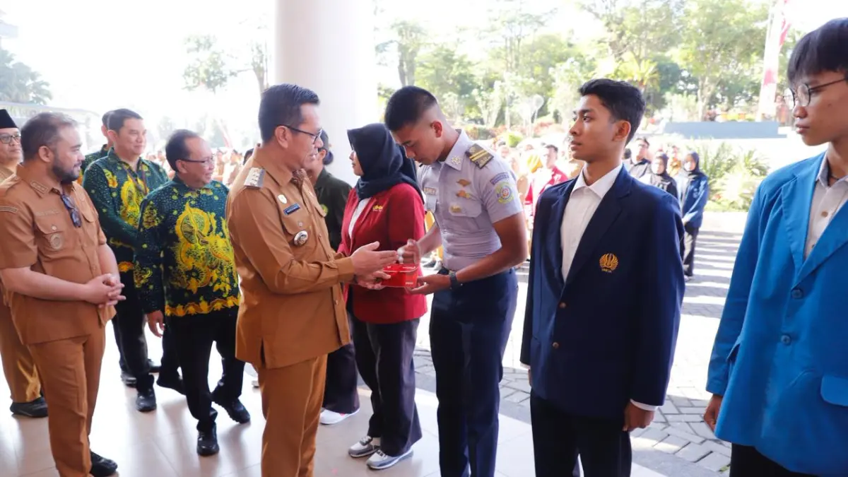 Wali Kota Batu Nurochman menyerahkan program beasiswa 1.000 Sarjana pada salah seorang mahasiswa di Balai Kota Among Tani Batu Senin lalu. (Rori Dinanda Bestari/Radar Batu)
