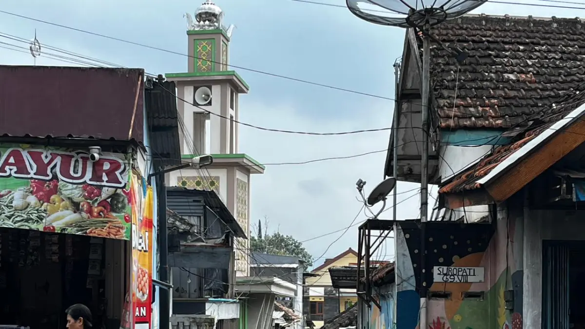 SUDAH DISASAR PAVINGISASI: Salah seorang pejalan kaki lewat di salah satu gang Desa Pesanggrahan, Kecamatan Batu (2/3) lalu. ZANADIA MANIK FATIMAH/RADAR BATU 