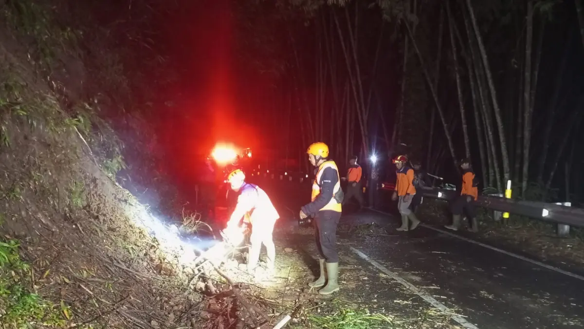 MENDADAK: Tebing yang ambrol sempat menutup sebagian badan jalan.