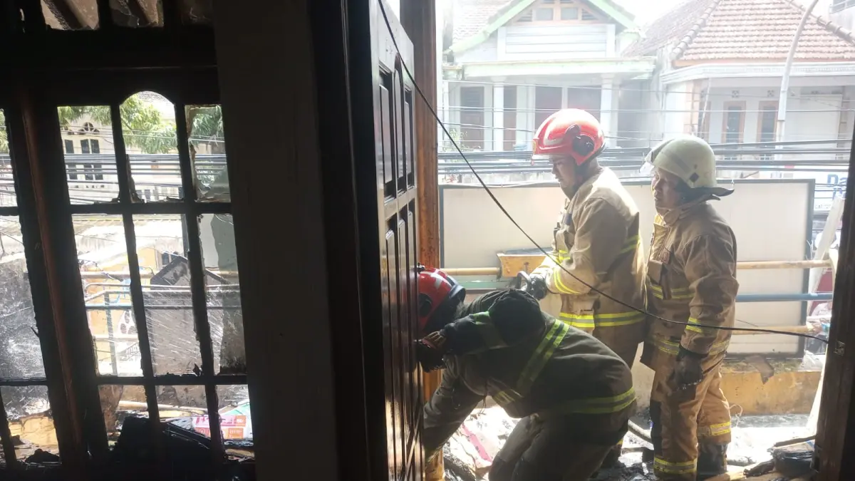 DIPADAMKAN: Petugas Damkarmat Kota Batu berjibaku memadamkan rembetan api yang menjalar di kios pakan kucing di Jalan WR Soepratman, Kelurahan Sisir, Kecamatan Batu kemarin (12/4). DAMKARMAT KOTA BATU FOR RADAR BATU