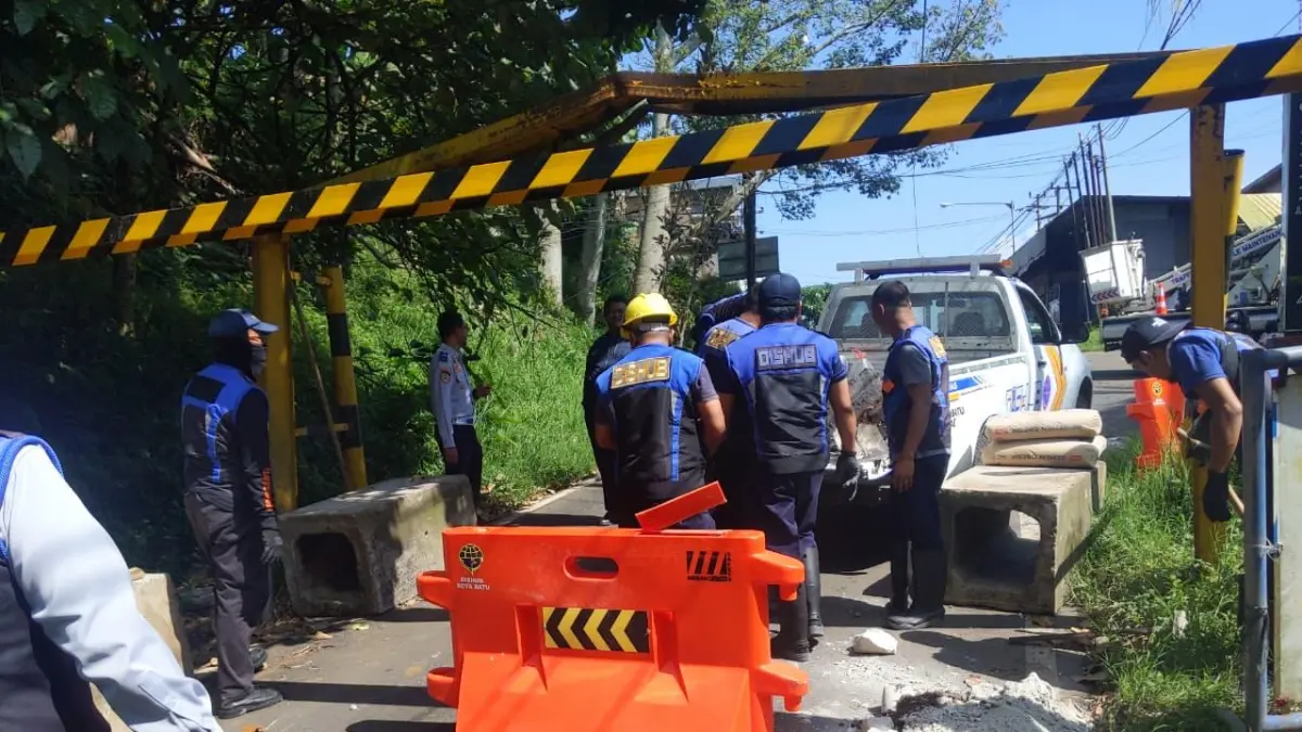 DILARANG LEWAT: Petugas Dishub Kota Batu memasang barrier beton di Jalan Rajakwesi alias Jalur Klemuk, Kelurahan Songgokerto, Kecamatan Batu kemarin (14/4). RORI DINANDA BESTARI/RADAR BATU