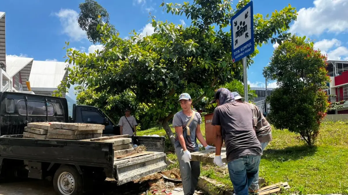 DIPINDAHKAN: Tiga pekerja mengangkat tutup u-ditch yang semrawut dan mengganggu mobilitas di kawasan Pasar Induk Among Tani kemarin (21/4). ZANADIA MANIK FATIMAH/RADAR BATU