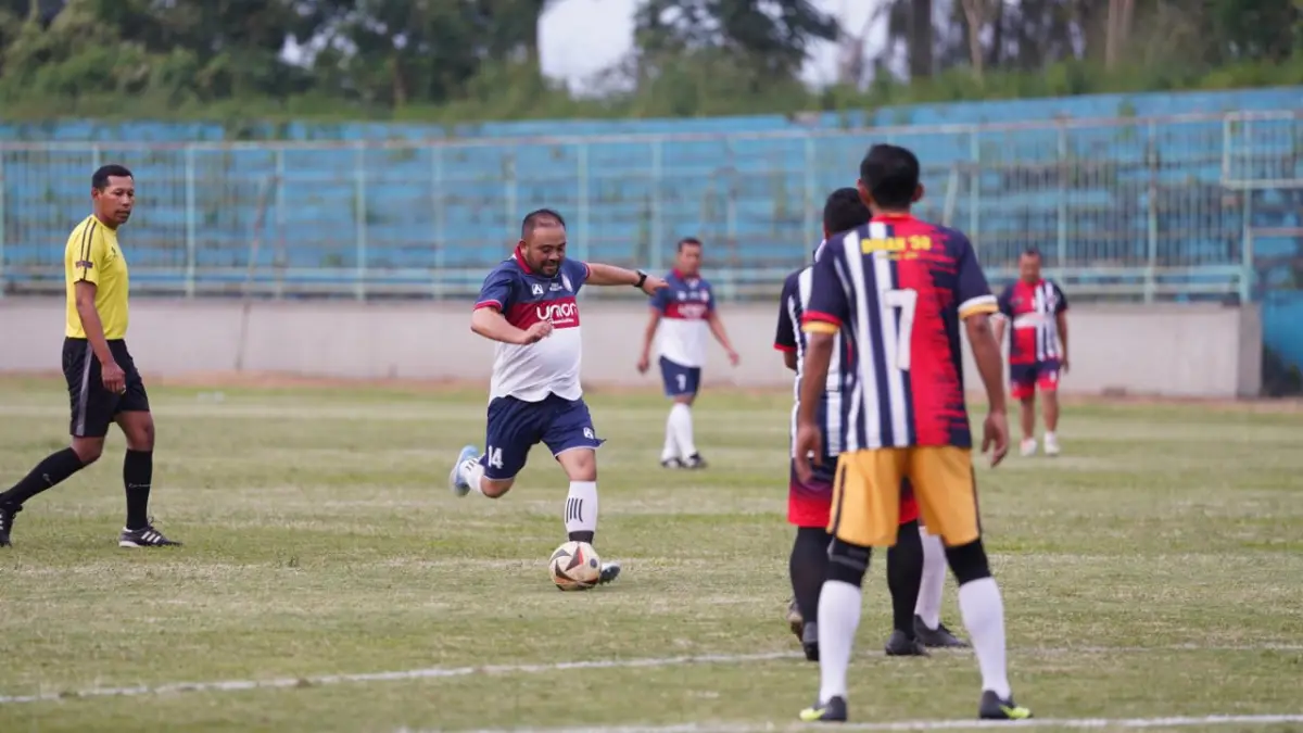 Pj Wali Kota Batu Heli Suyanto menendang bola ke gawang lawan di Stadion Brantas yang baru saja diperbaiki. (Prokopim Kota Batu)