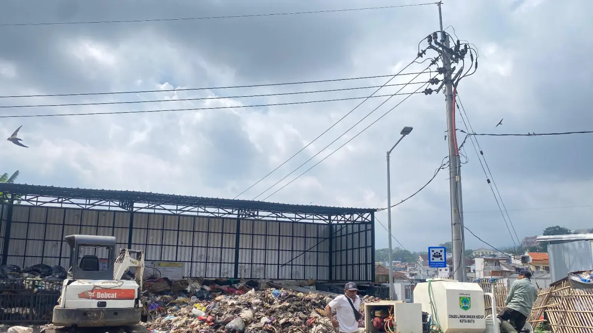 BAKAL DIOLAH: Salah seorang petugas bersiap melakukan penyemprotan sampah di Pasar Induk Among Tani Batu beberapa waktu lalu.
