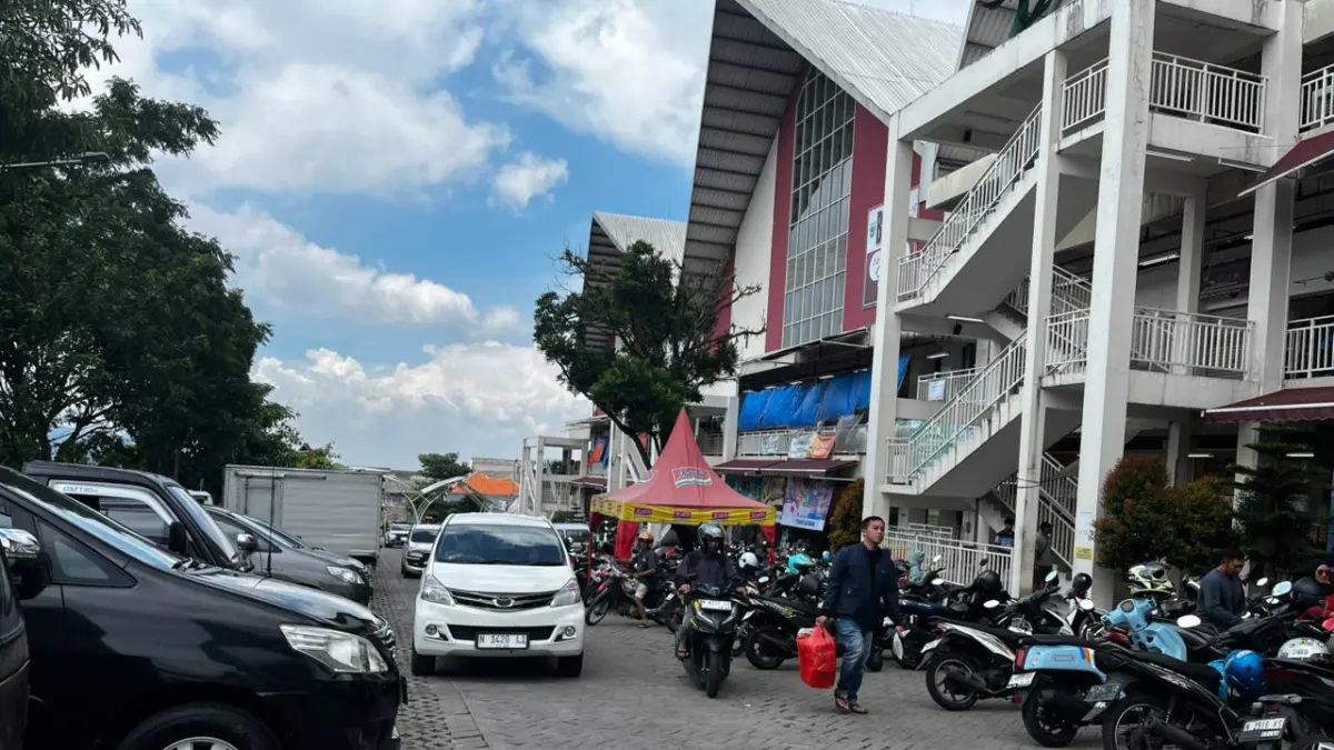 GATE PARKIR: Sejumlah orang melewati pintu parkir Pasar Induk Among Tani beberapa hari lalu.