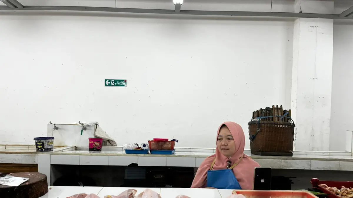 MENIPIS: Salah seorang pedagang ayam di Pasar Induk Among Tani menjaga kios miliknya beberapa hari lalu.