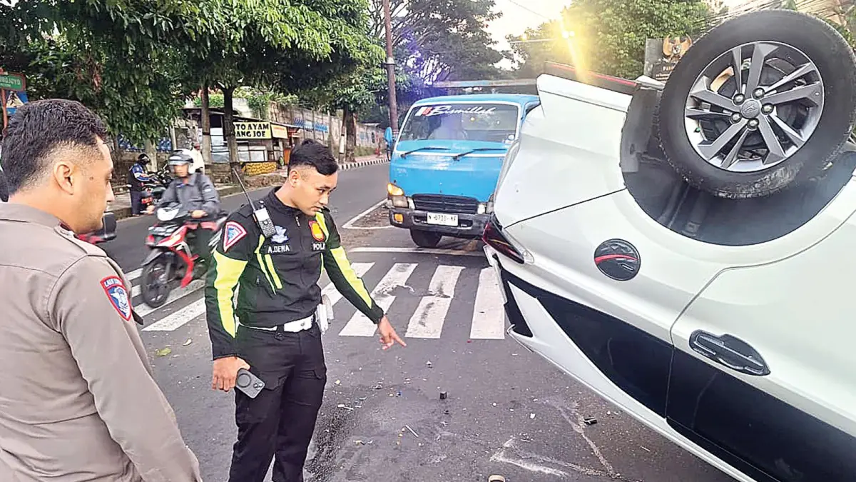 RUSAK PARAH: Petugas Satlantas Polres Batu melakukan olah TKP pascalaka beruntun yang mengakibatkan Mobil Xenia bernopol N 1982 AAV terbalik di perempatan Pesanggrahan kemarin (5/5). 