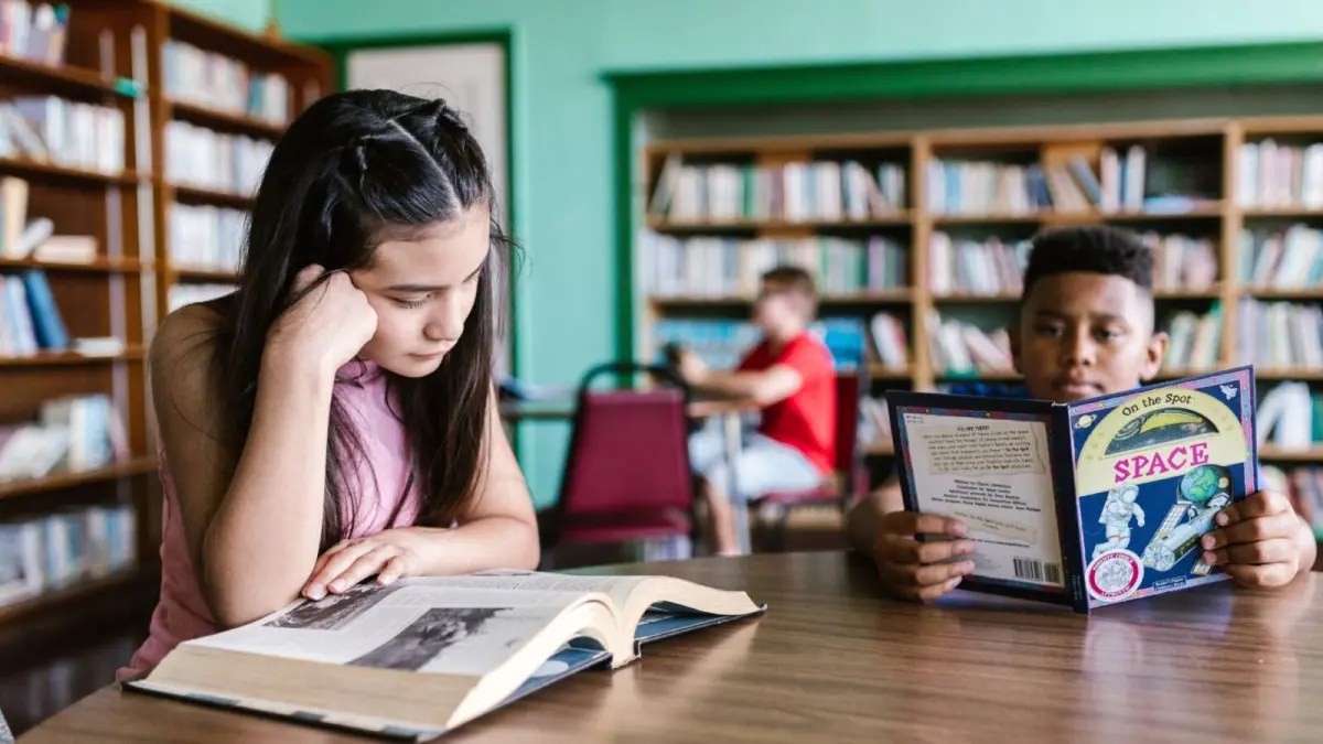 Ilustrasi siswa membaca buku diperpustakaan dengan siswa lain (Sumber: Masoem University)