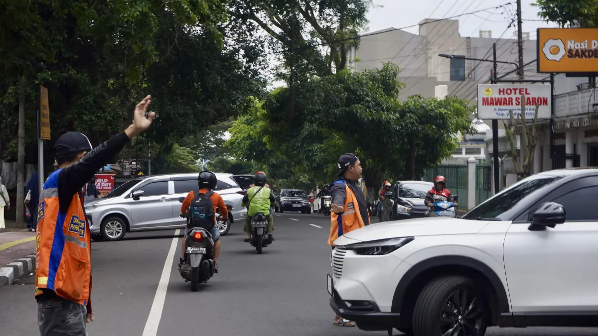 JADI SOROTAN: Sejumlah jukir membantu memarkirkan kendaraan di Jalan Diponegoro, Kecamatan Batu beberapa hari lalu.