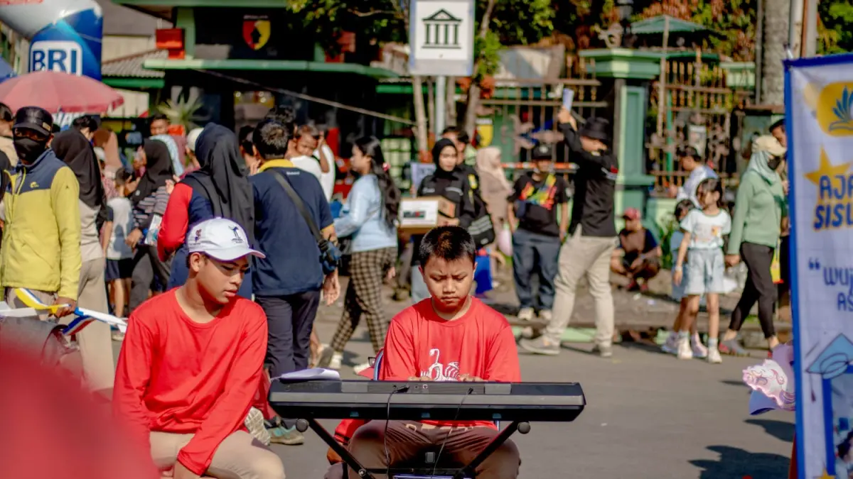 MEMUKAU: Evan Alviano Atmaja unjuk kepiawaian menekan tuts piano di Car Free Day Kota Malang beberapa waktu lalu. Aksinya memukai banyak pengunjung di sana. 