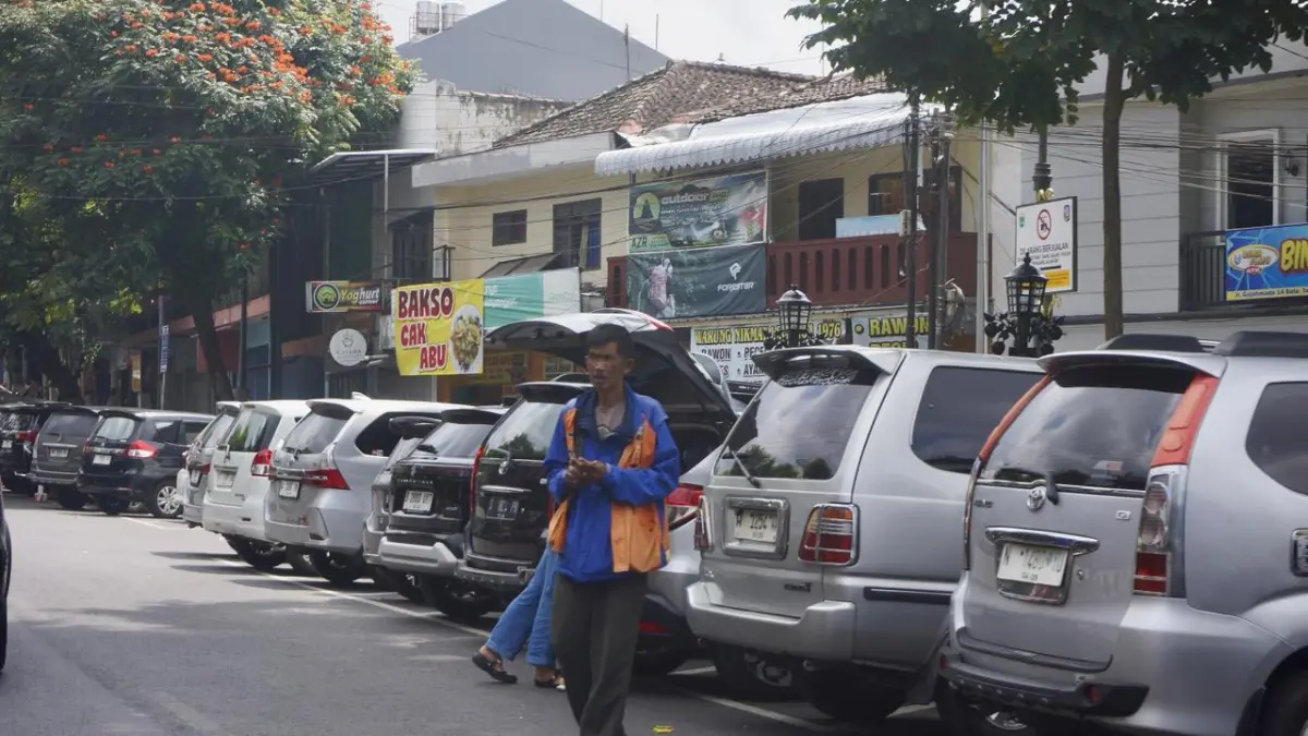 REALISASI SERET: Jukir di kawasan Jalan Gajah Mada membantu sejumlah kendaraan yang hendak meninggalkan satuan ruang parkir beberapa hari lalu.