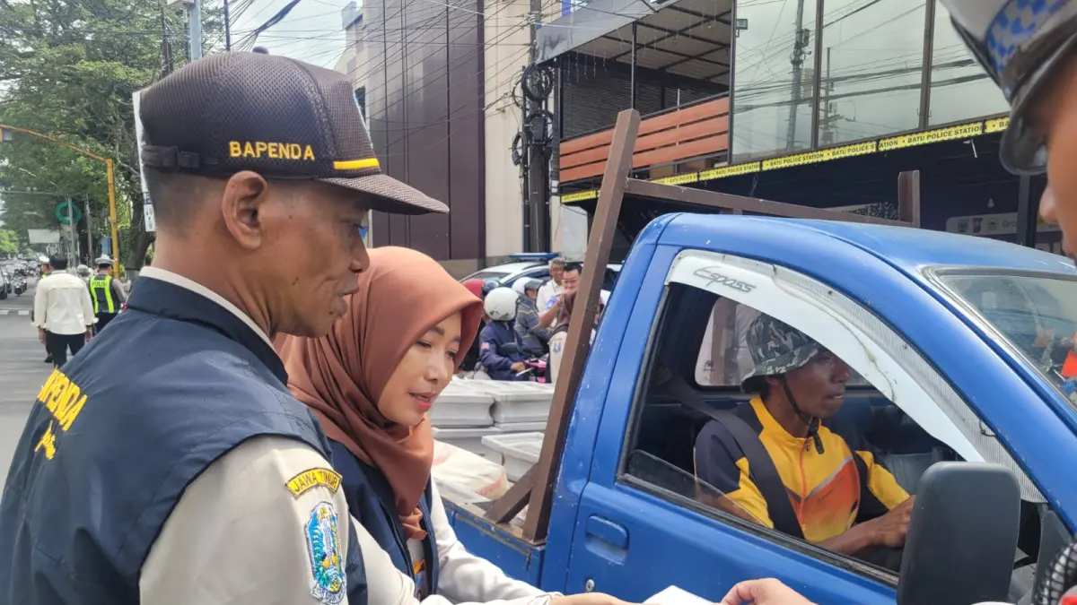 JEMPUT BOLA: Petugas Bapenda bersama Satlantas Polres Batu menjaring pengendara motor yang menunggak pajak dalam razia gabungan beberapa hari lalu. Langkah represif diambil demi mengamankan target pendapatan daerah.