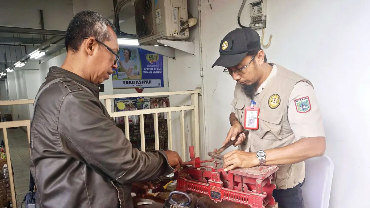 DITERA ULANG: Petugas Diskumperindag Kota Batu mengecek alat ukur berupa timbangan manual di Pasar Induk Among Tani Kota Batu pada Rabu lalu (20/5).