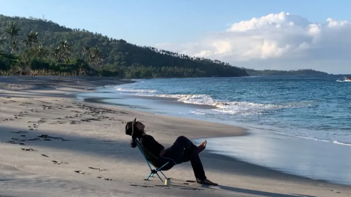 Ilustrasi seseorang yang sedang healing di tepi pantai (Sumber: Fakultas Psikologi UNESA)