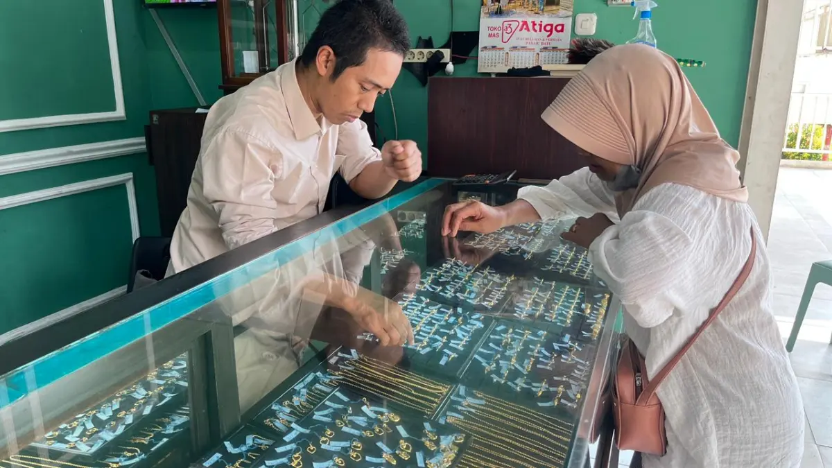 TURUN HARGA: Seorang pelanggan melihat-lihat koleksi perhiasan di Toko Emas Atiga, Pasar Induk Among Tani Kota Batu beberapa hari lalu.
