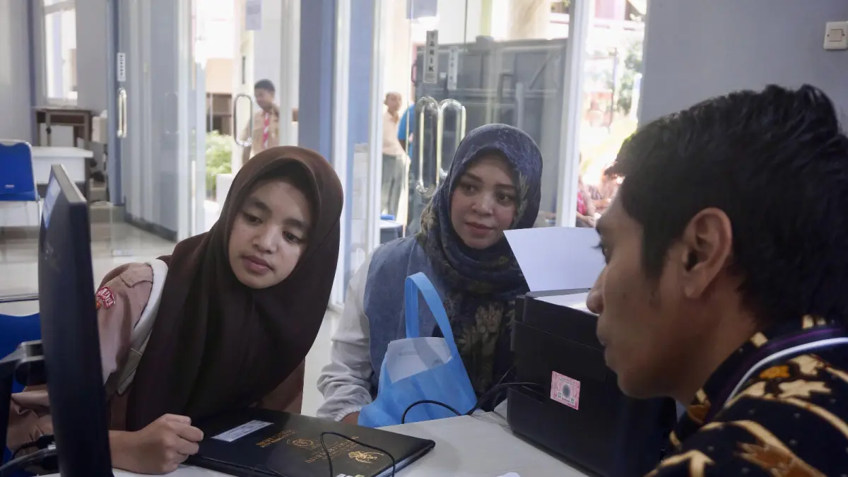ANIMO TINGGI: Seorang calon siswa didampingi orang tuanya melakukan verifikasi titik koordinat dan pengambilan PIN di posko pelayanan SMA Negeri 1 Batu kemarin (29/5). Akurasi peta digital menjadi syarat mutlak penentu kelulusan jalur zonasi.