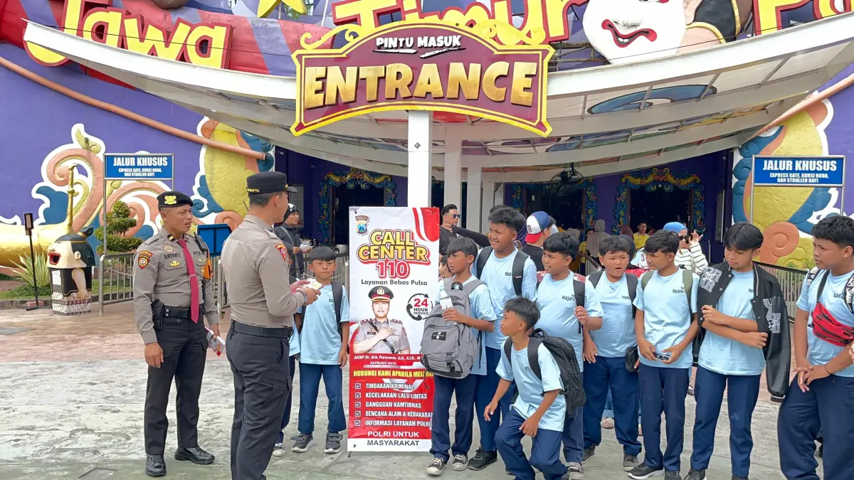 SOSIALISASI: Kabag Ops Polres Kota Batu AKP Hendro Utaryo mengedukasi wisatawan terkait layanan Call Center 110 di kawasan Jatim Park 1 guna mengantisipasi gangguan keamanan dan ketertiban.