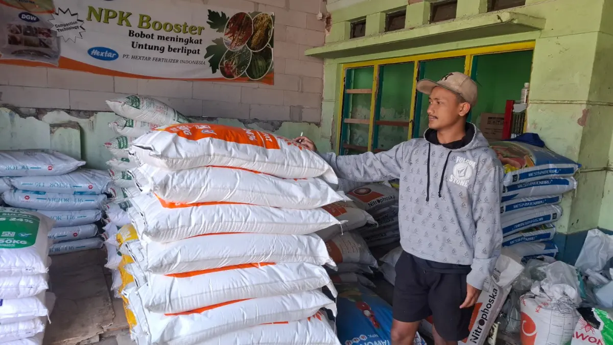 EKONOMI: Rizal, pemilik toko pertanian dan peternakan di Desa Tlekung, Kecamatan Junrejo menunjukkan pupuk yang sedang mengalami kenaikan harga signifikan.