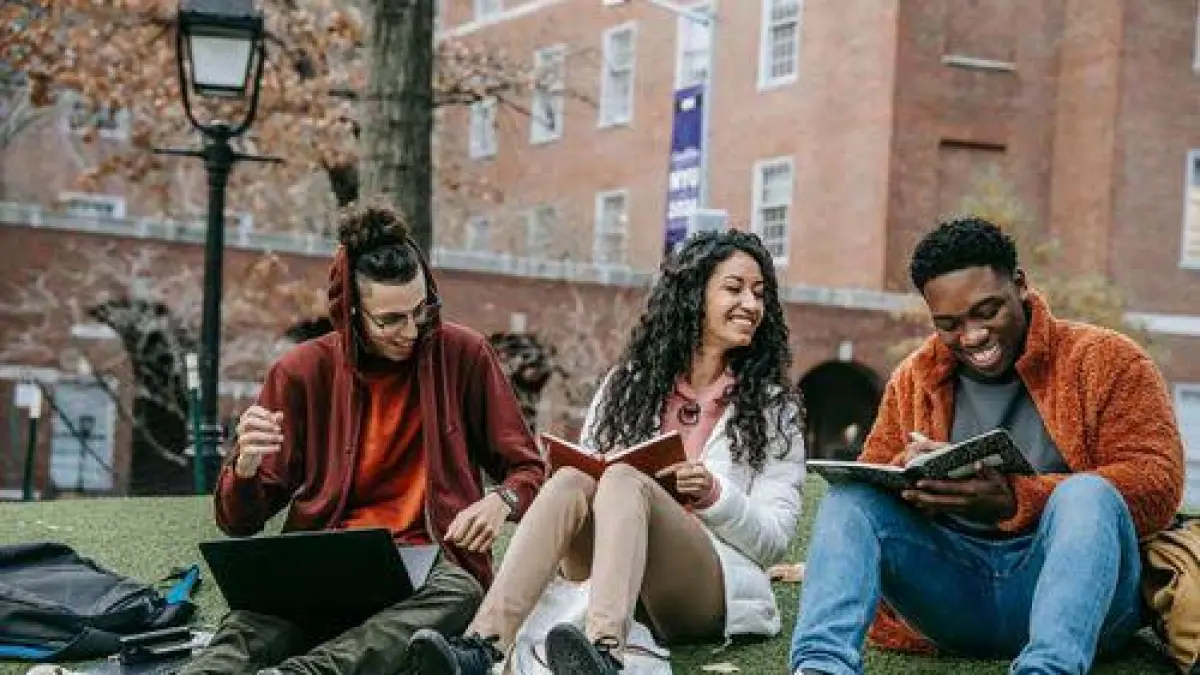 Tiga orang mahasiswa yang sedang belajar bersama di halaman kampus (Sumber: Primakara University)