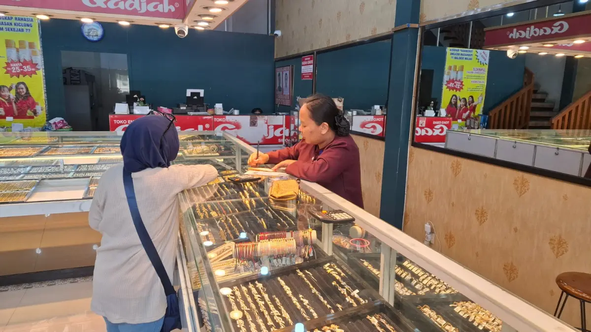 EMAS ANJLOK: Salah seorang pramuniaga di Toko Emas Ratnasari 2 Pasar Among Tani Kota Batu melayani konsumen beberapa waktu lalu.