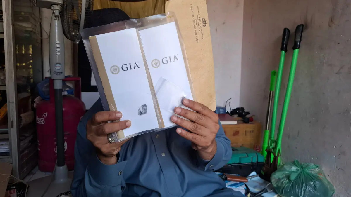 PENIPUAN: Korban penipuan berlian palsu menunjukkan barang bukti penipuan sertifikat Gemological Institute of America (GIA) dan dua berlian palsu.