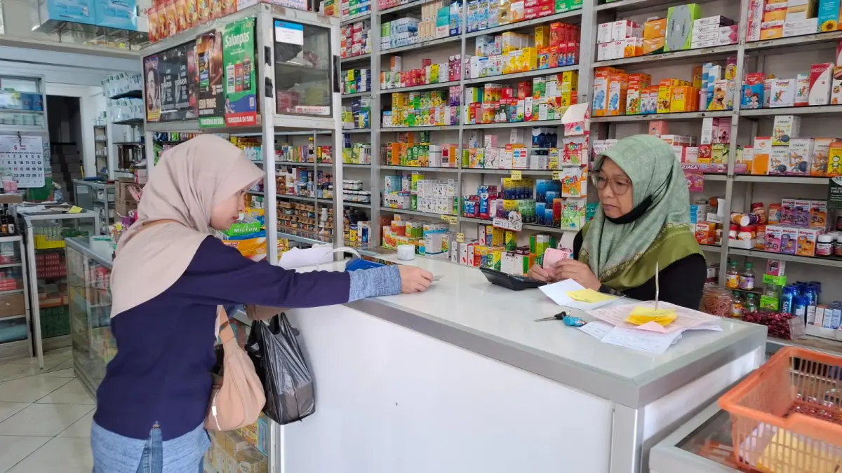 KENAIKAN: Triatin melayani pembeli yang mencari obat di tokonya di Jalan Diponegoro.
