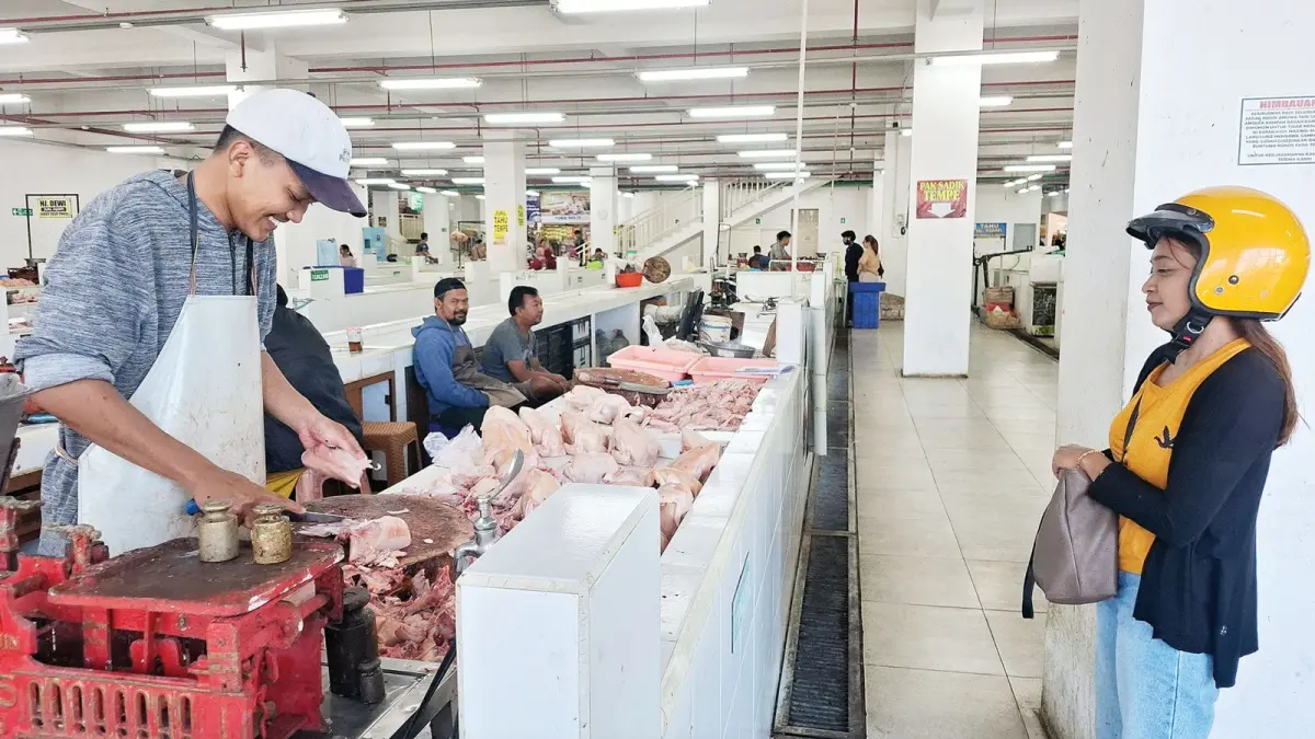 SEPI PEMBELI: Penjual memotong daging ayam pesanan pembeli di Pasar Among Tani Kota Batu beberapa hari lalu.