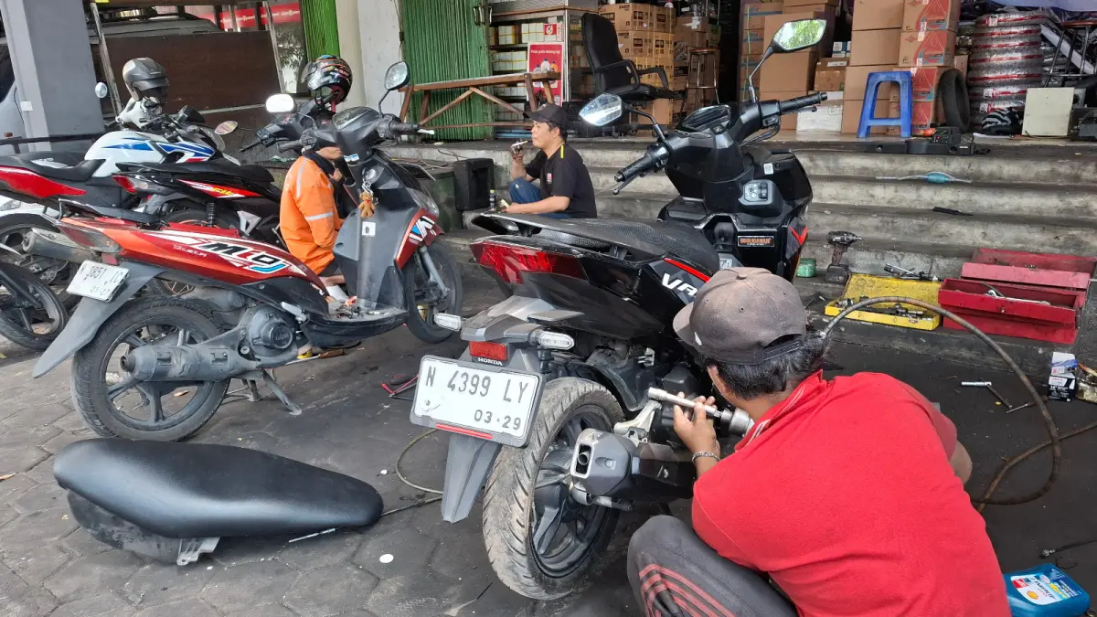 RAWAN RUSAK: Seorang mekanik tengah memperbaiki mesin sepeda motor di bengkel Hippo Motor, Jalan Hasanudin, Kecamatan Batu, kemarin (22/6). Penggunaan bahan bakar yang tidak sesuai kompresi mesin memicu kerusakan jangka panjang.