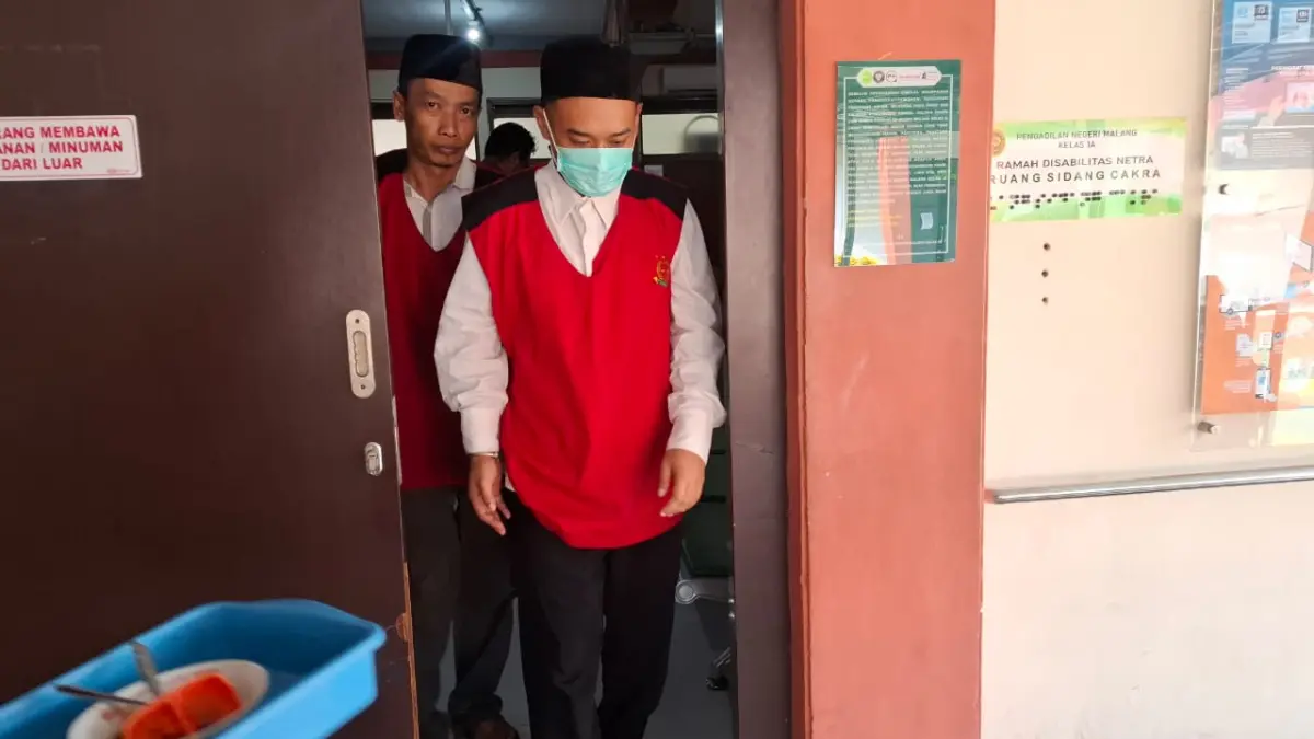 PENCURIAN: Terdakwa pencurian logam mulia sebanyak 220 keping, Rio keluar dari ruang persidangan Pengadilan Negeri Kota Malang kemarin (24/6)