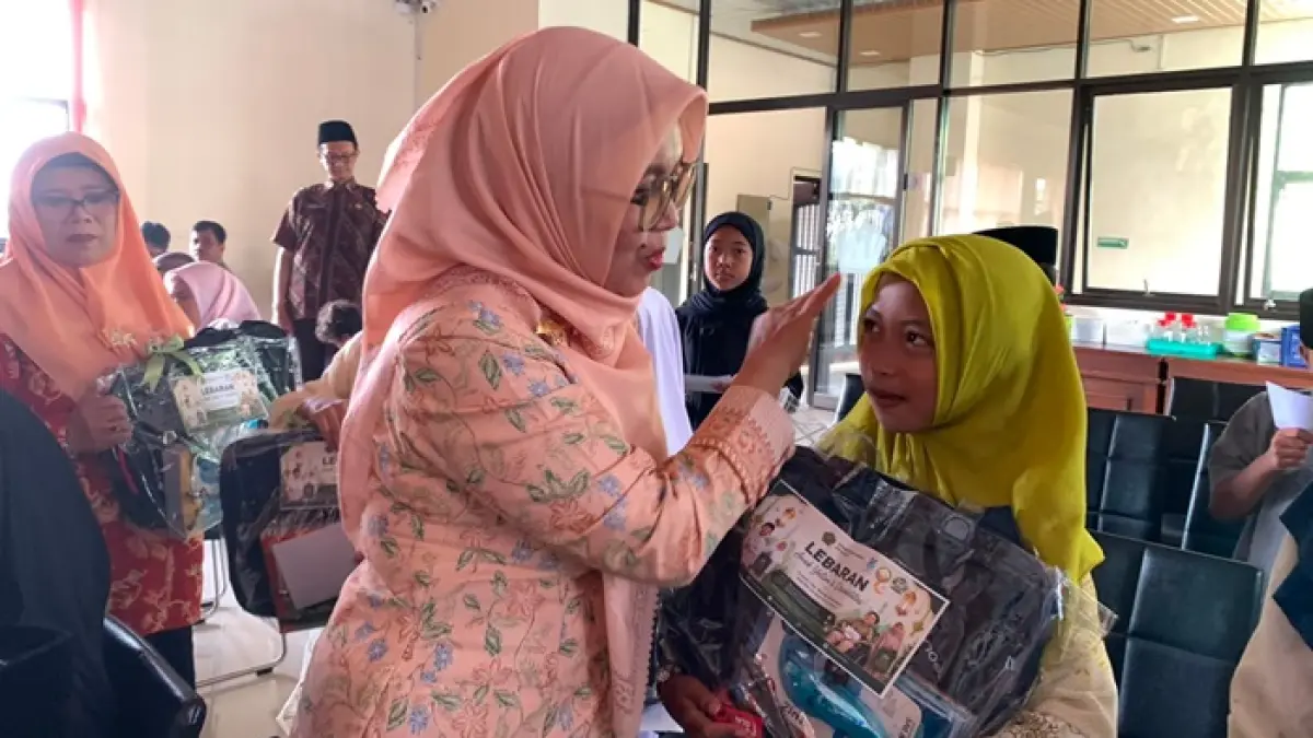 LEBARAN YATIM: Panitia acara lebaran yatim berikan perhatian hangat ke salah satu anak di tengah-tengah proses penyaluran santunan di gedung Pusat Layanan Haji dan Umrah Terpadu (PLHUT) Kota Batu kemarin (25/6).